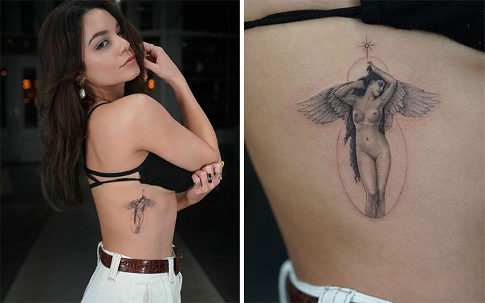 Celebrity tattoo of an angel on a Vanessa Hudgen's side, wearing a black top and white pants, in a dimly lit space.