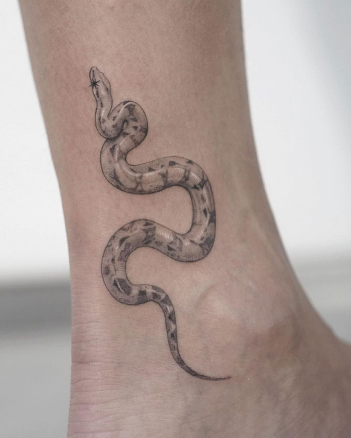 Snake tattoo on ankle of a celebrity, showing intricate details and shading, part of a collection of celebrity tattoos.