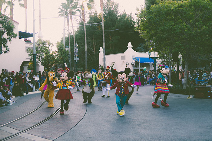 Disney characters in colorful costumes performing in a parade, showcasing big trends that we almost forgot existed.