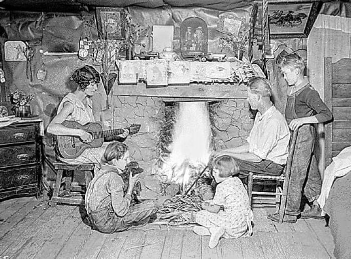 Photo Of A Family Gathered Around The Fireplace In Their Home