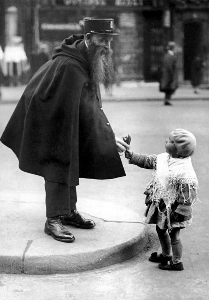 C. 1929. Una niña entrega lirios a un policía de servicio en la Puerta Saint-Denis de París