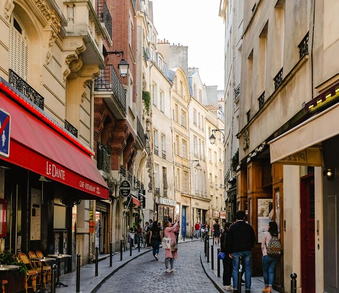 Narrow street on Paris filles with people 
