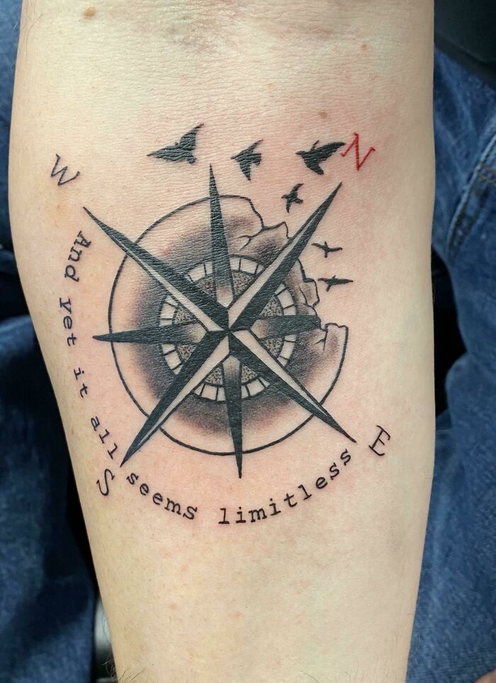 Compass tattoo with birds and the words "And yet it all seems limitless," reflecting meaningful word tattoos.