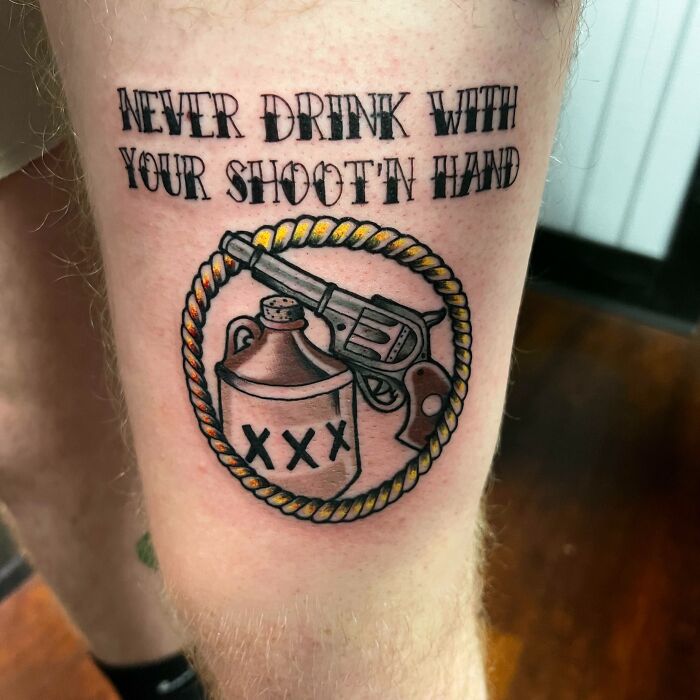 Tattoo of a revolver and jug with rope frame and text "Never drink with your shoot'n hand," emphasizing word tattoos.