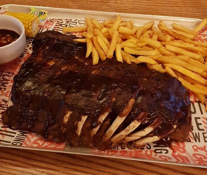Huge Ribs With Chips, BBQ Beans, Coleslaw, And Corn On The Cob