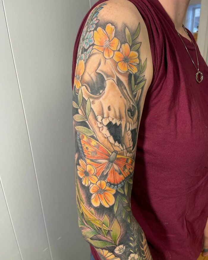 Skull of coyote and orange flowers tattoo