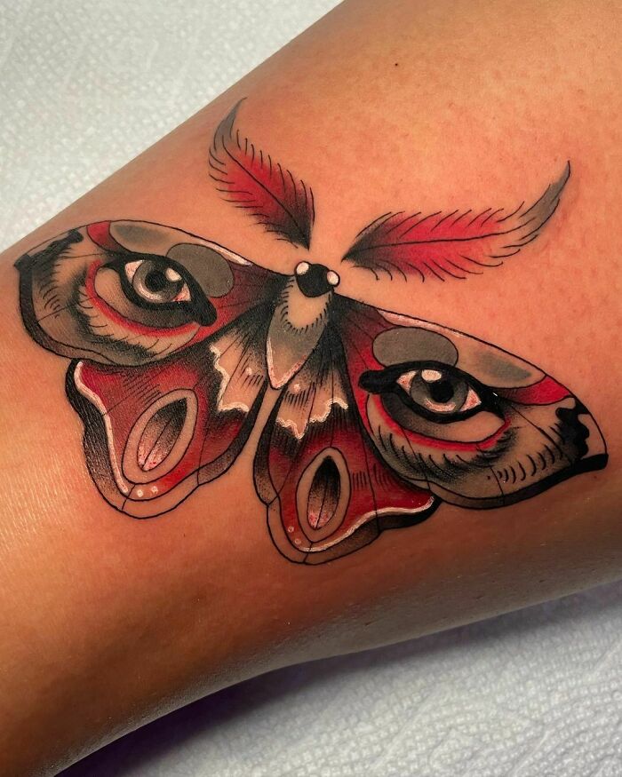 Butterfly tattoo with eye patterns on wings, showcasing bold nature design elements.