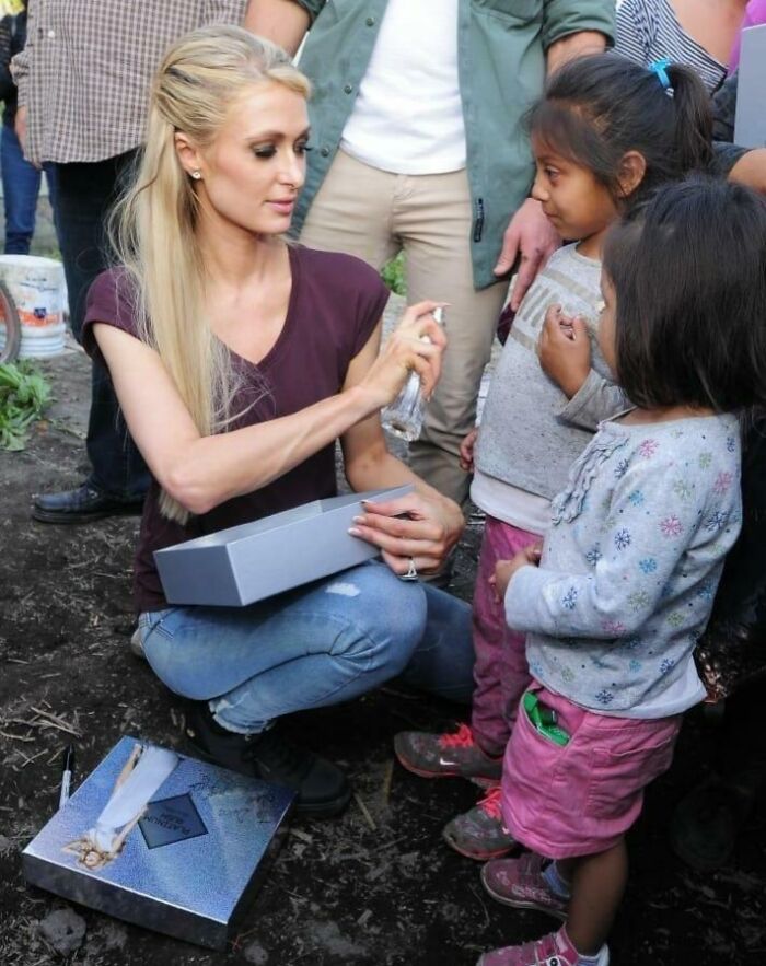 Paris Hilton promocionando sus productos y rociando con su perfume a las víctimas de un terremoto en 2018 