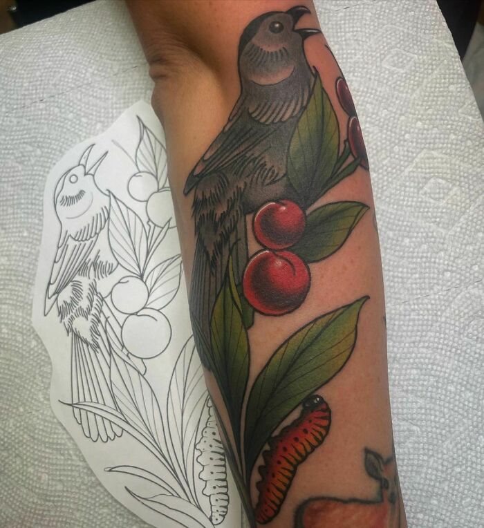 Colorful bird and berries arm tattoo 