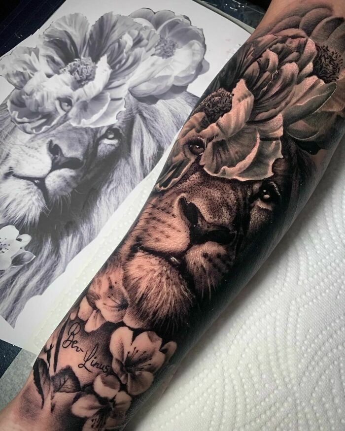 Detailed lion and flower nature tattoo on arm, showcasing artistic wild side expression.