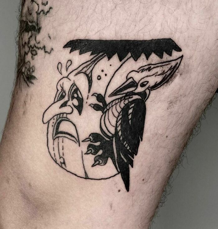 Nature tattoo featuring a stylized bird and face inked on skin with bold black outlines.