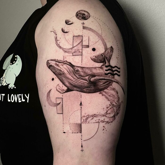 Whale-themed nature tattoo on an arm, featuring geometric shapes and celestial designs.