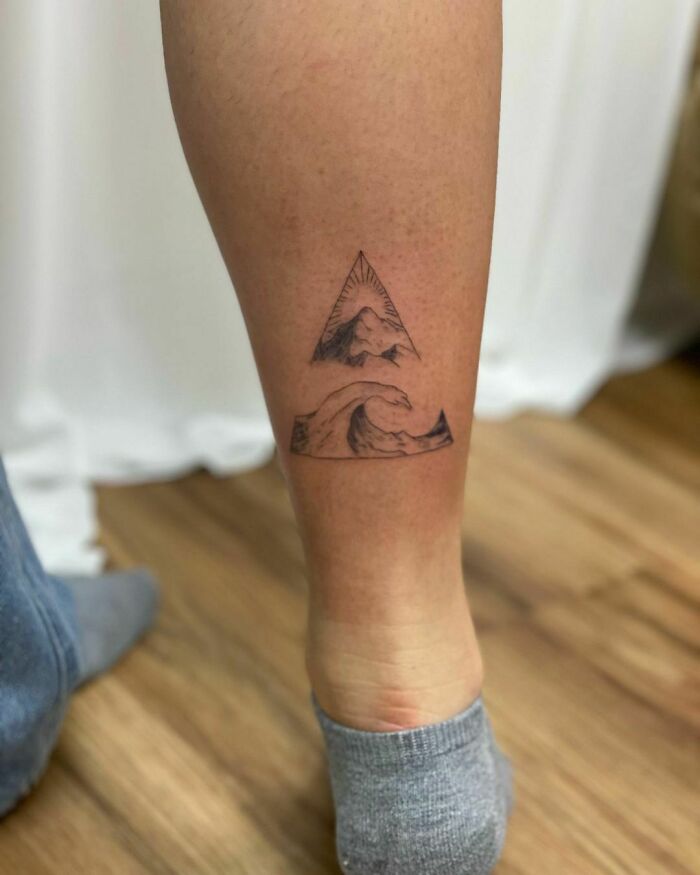 Leg tattoo featuring a mountain and wave design, perfect for nature tattoo enthusiasts with a wild side.