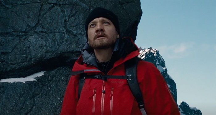 Jeremy Renner wearing red jacket and looking in movie The Bourne Legacy