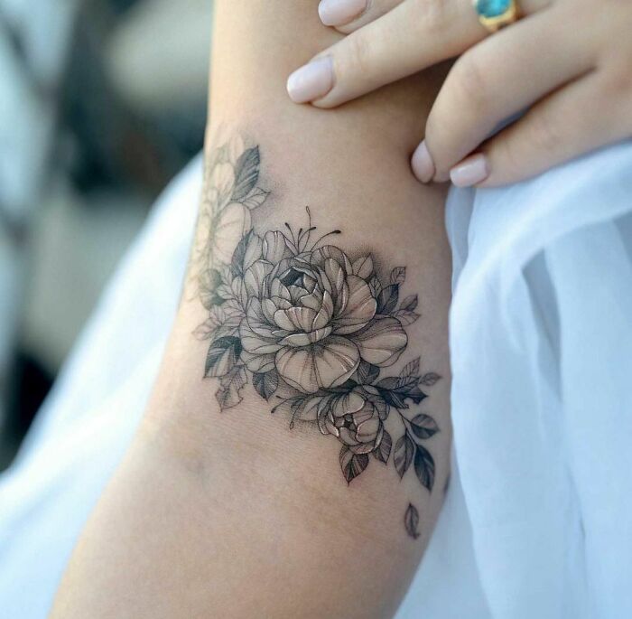 Delicate floral nature tattoo on forearm with intricate detailing, showcasing a wild side.