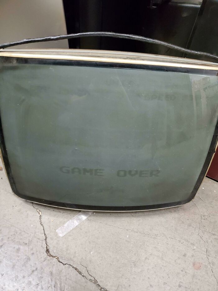 Un televisor de tubo roto en mi trabajo tiene "Game Over" grabado en la pantalla