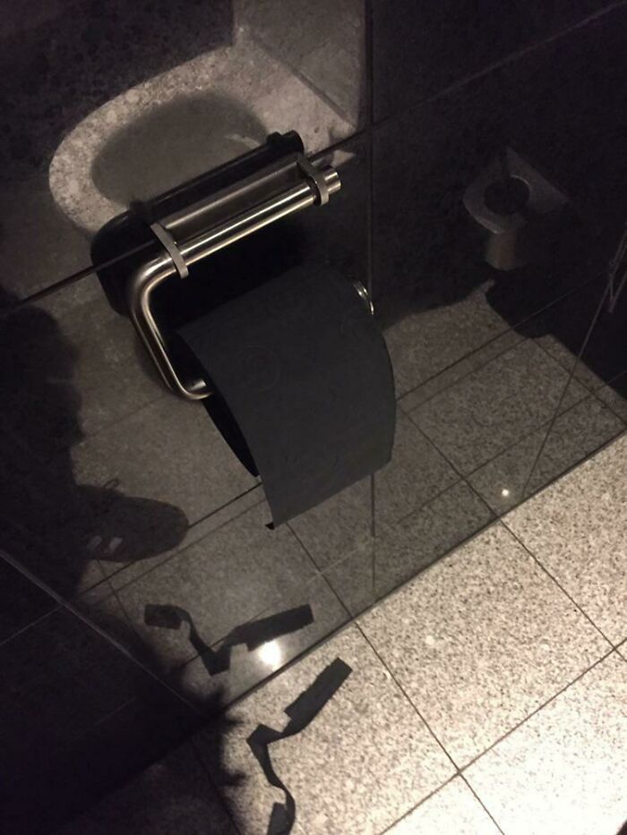 Este baño público de un hotel tiene papel higiénico negro