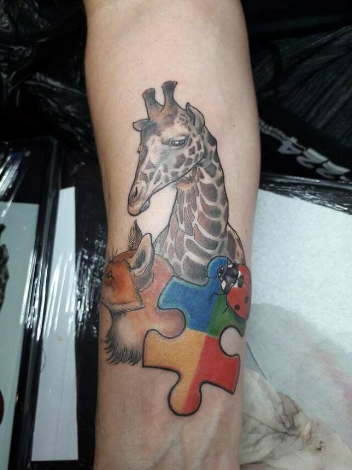 Giraffe, fox, ladybird and colorful puzzle piece tattoo