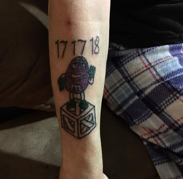 Funny tattoo of a purple character with numbers 17 17 18 on an arm.
