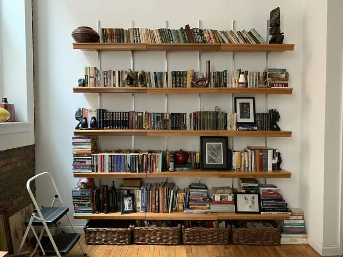 Brown bookshelf with books and frames 