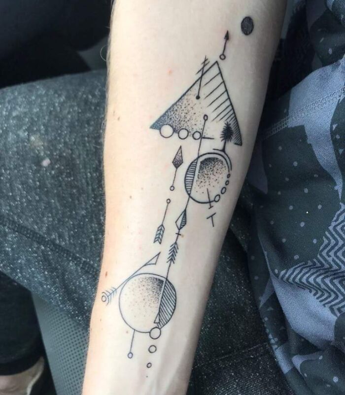 Geometric composition with triangles and arrows tattoo on forearm