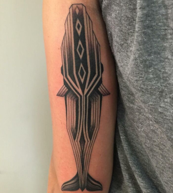 Geometric tattoo featuring an intricate whale design on a person's arm.