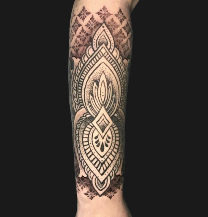Intricate geometric tattoo design on forearm, showcasing creative shapes and forms in black ink.