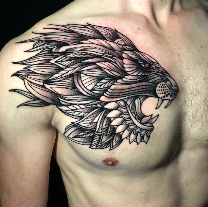 Fierce geometric style lion head tattoo on chest