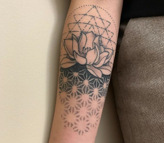 Geometric tattoo on forearm with lotus flower and intricate shapes, showcasing creativity and forms.