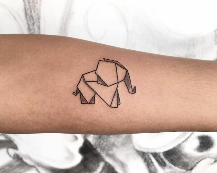 Geometric tattoo of an origami elephant on an arm, showcasing creative shapes and forms.