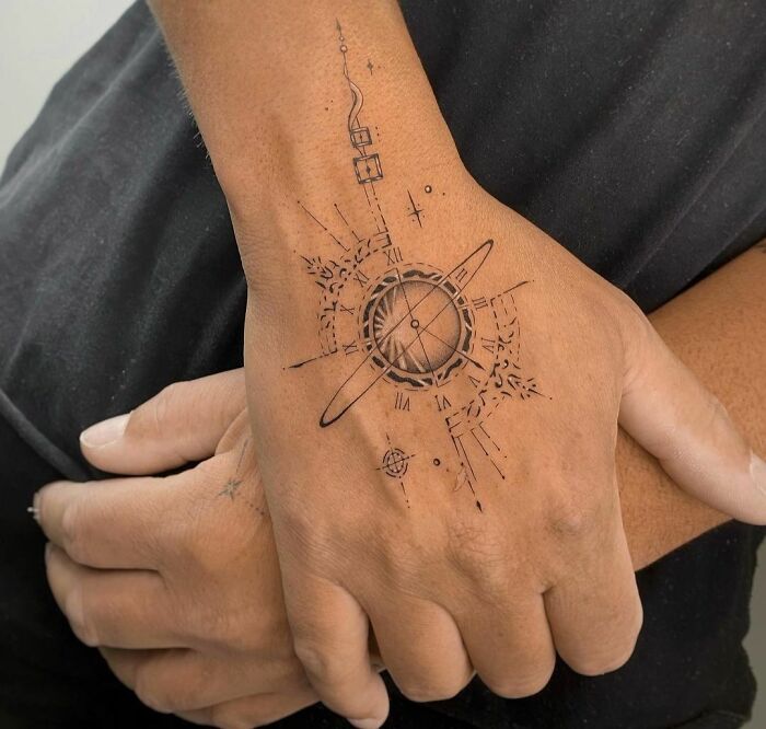 Geometric cosmic Saturn tattoo on hand