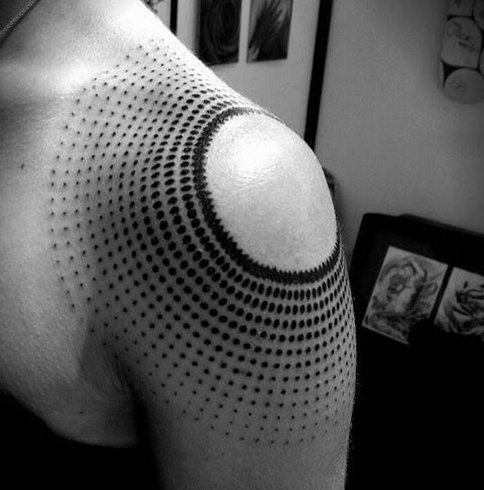 Geometric tattoo with dot patterns on shoulder, showcasing creativity.