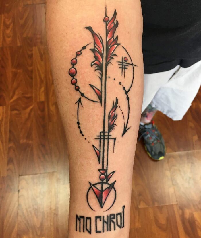 Red and black geometric arrow tattoo