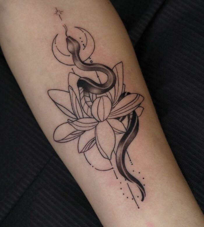 Geometric tattoo with a snake and lotus flower design on forearm.