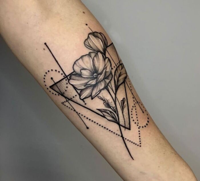 Geometric tattoo with floral design on forearm, featuring shapes, lines, and creative forms.