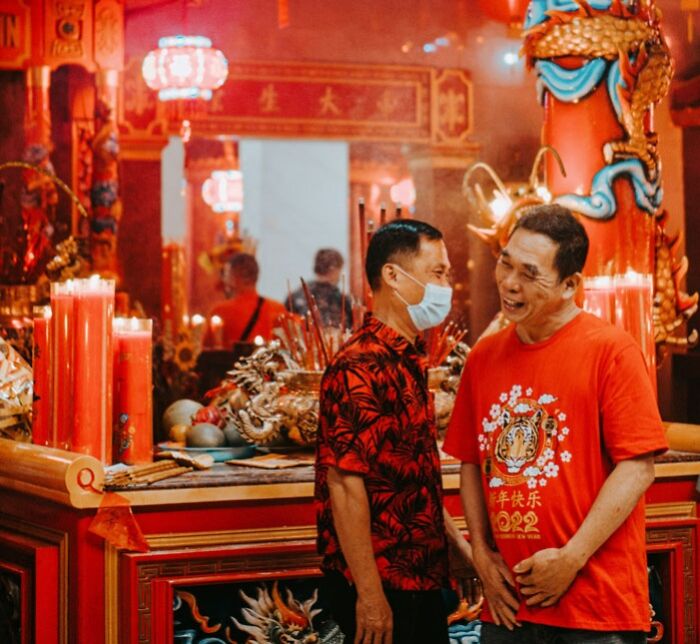 Two men laughing and celebrating Chinese New Year in a Temple