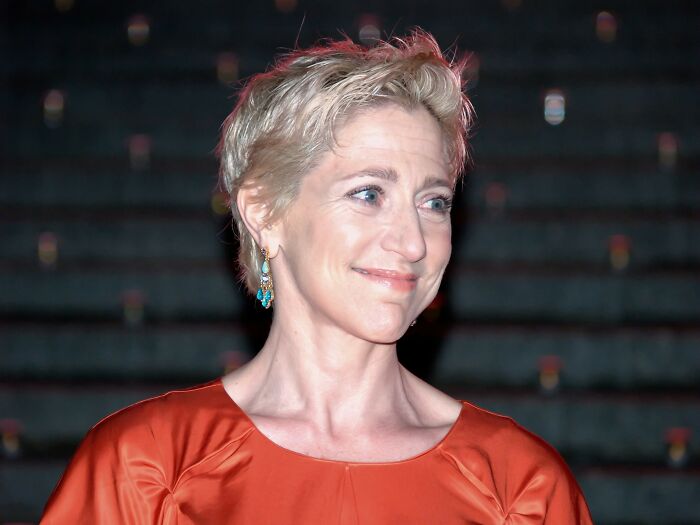 Edie Falco in an orange dress at an event, featured among celebrities who never married yet found love.