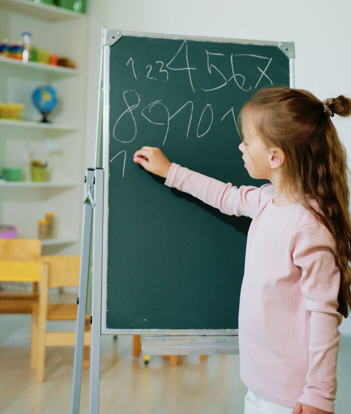 Girl Writing Numbers On The Board 