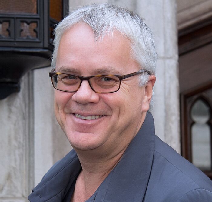 Tim Robbins wearing glasses and a dark jacket, representing celebrities who never married yet found love.