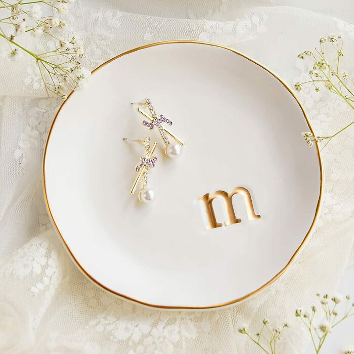 Jewelry plate with earrings on lace, featuring a gold letter "m" for home organization ideas.