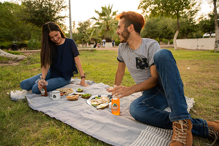  A couple enjoys a taco picnic on grass