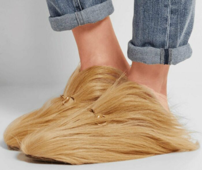 Weird shoes with long blonde hair design, worn with rolled-up jeans.