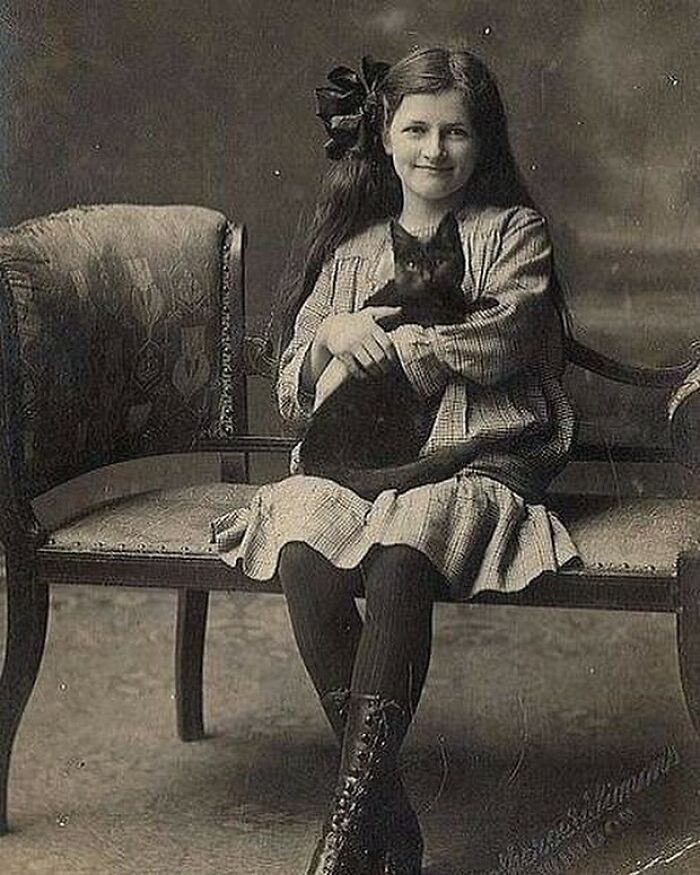 Una jovencita inglesa victoriana posando con su gato, alrededor de la década de 1890
