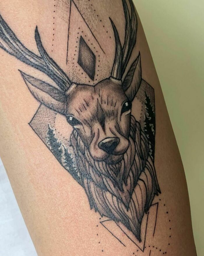 Geometric tattoo with deer and abstract shapes on arm.