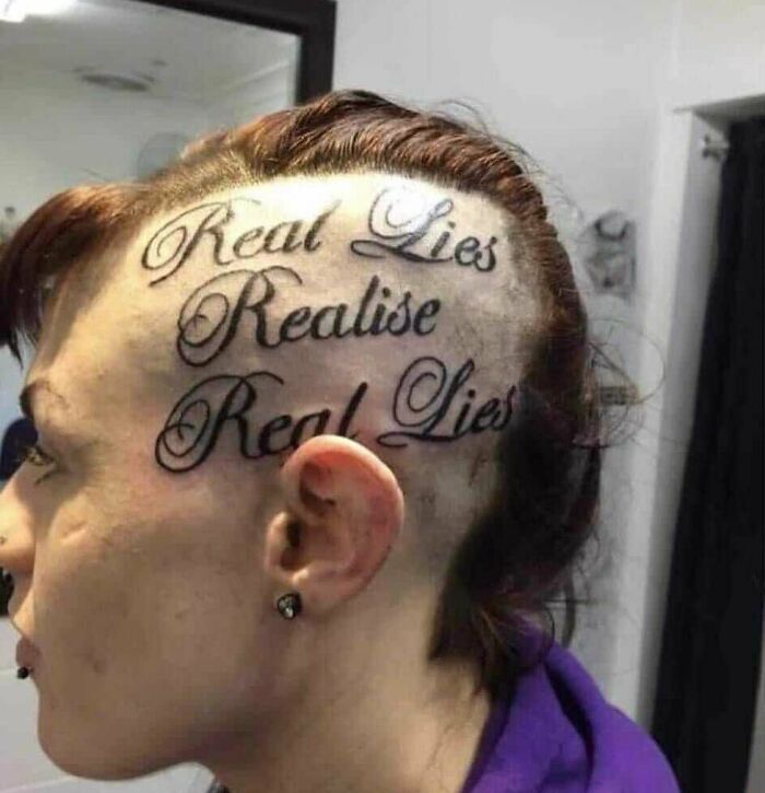 Person with large text tattoo on shaved side of head expressing a phrase about lies.