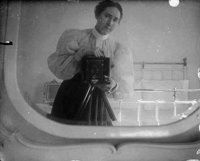 Una joven victoriana tomándose una fotografía en el espejo. Alrededor de 1900