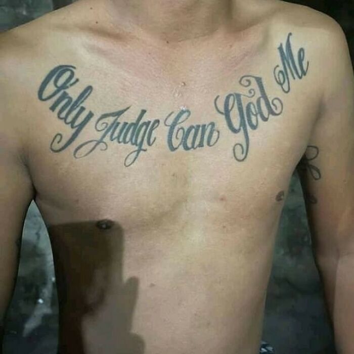 Chest tattoo reads "Only Judge Can God Me" showing a tattoo fail.