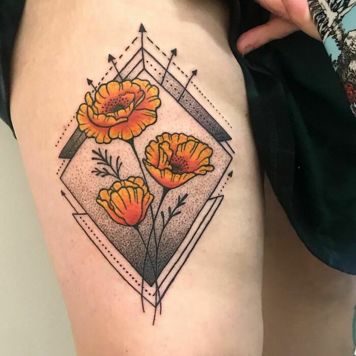 Geometric tattoo with orange flowers in a diamond shape, featuring intricate linework and dot shading.