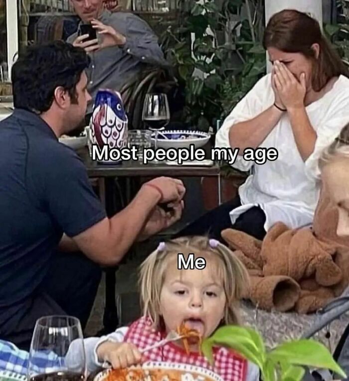 A man proposing while a child humorously eats spaghetti, highlighting funny therapy meme themes.