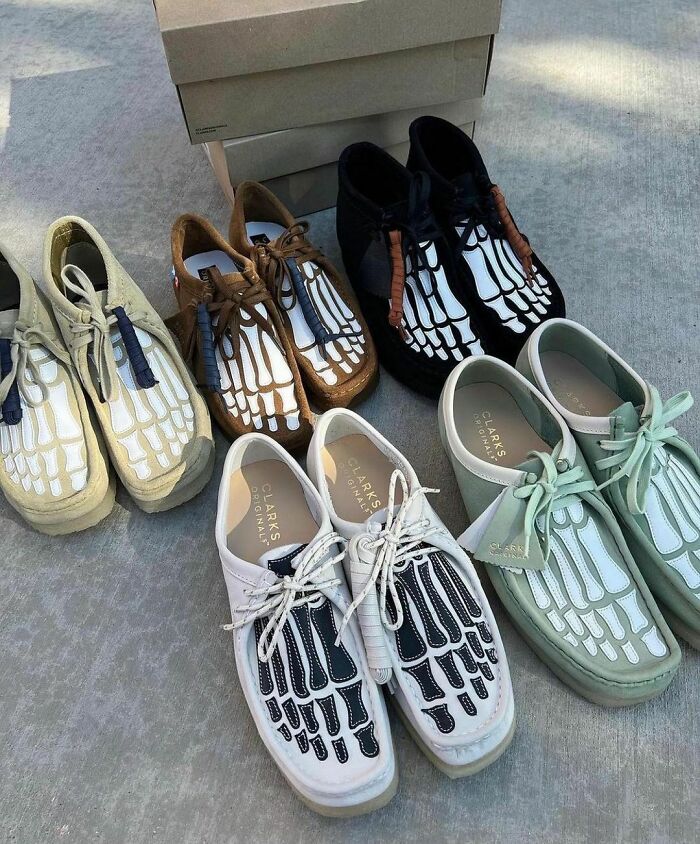 Weird shoes featuring skeleton foot designs in various colors displayed on a concrete floor.